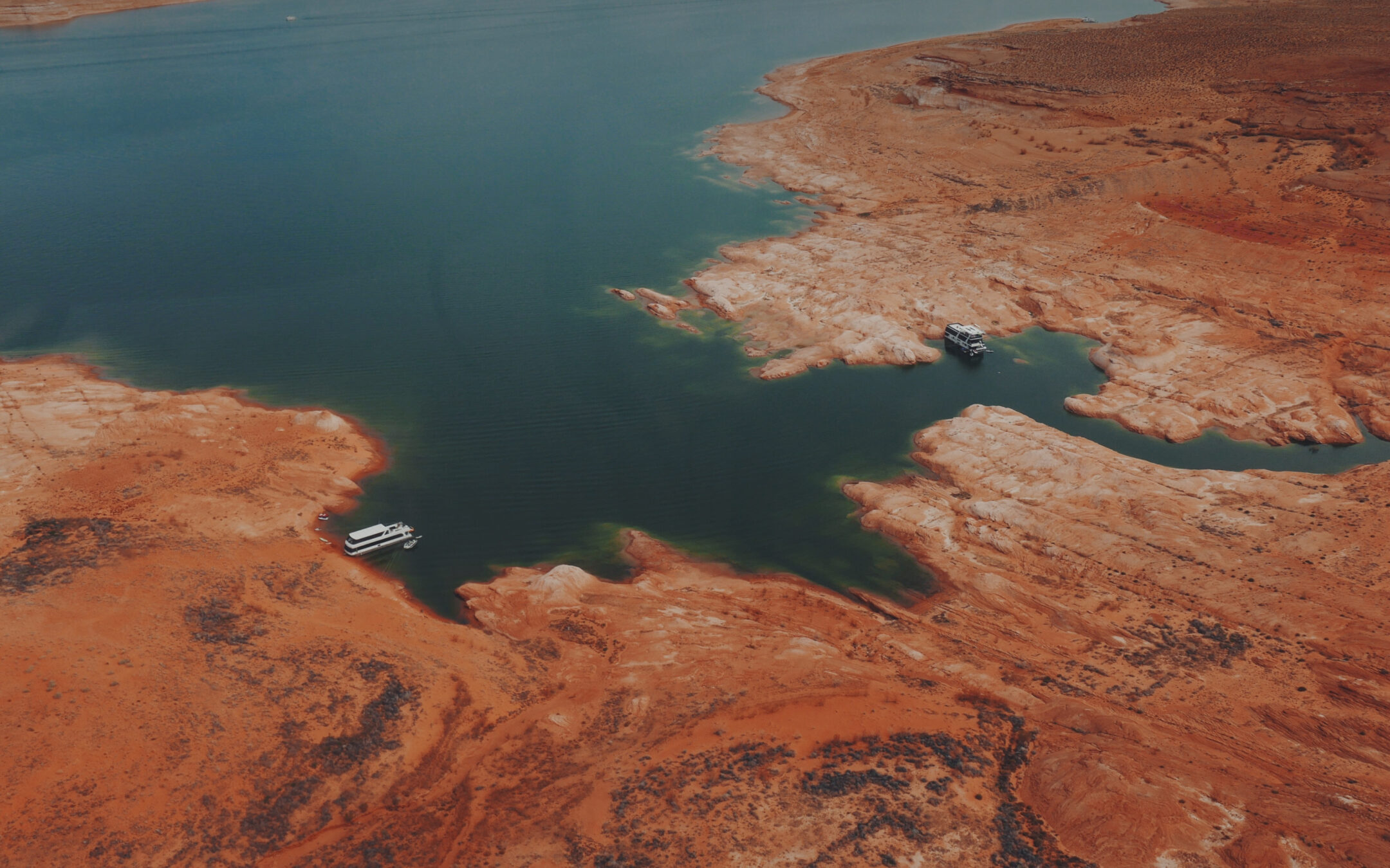 aerial view of lake powell showing two boats on the shoreline